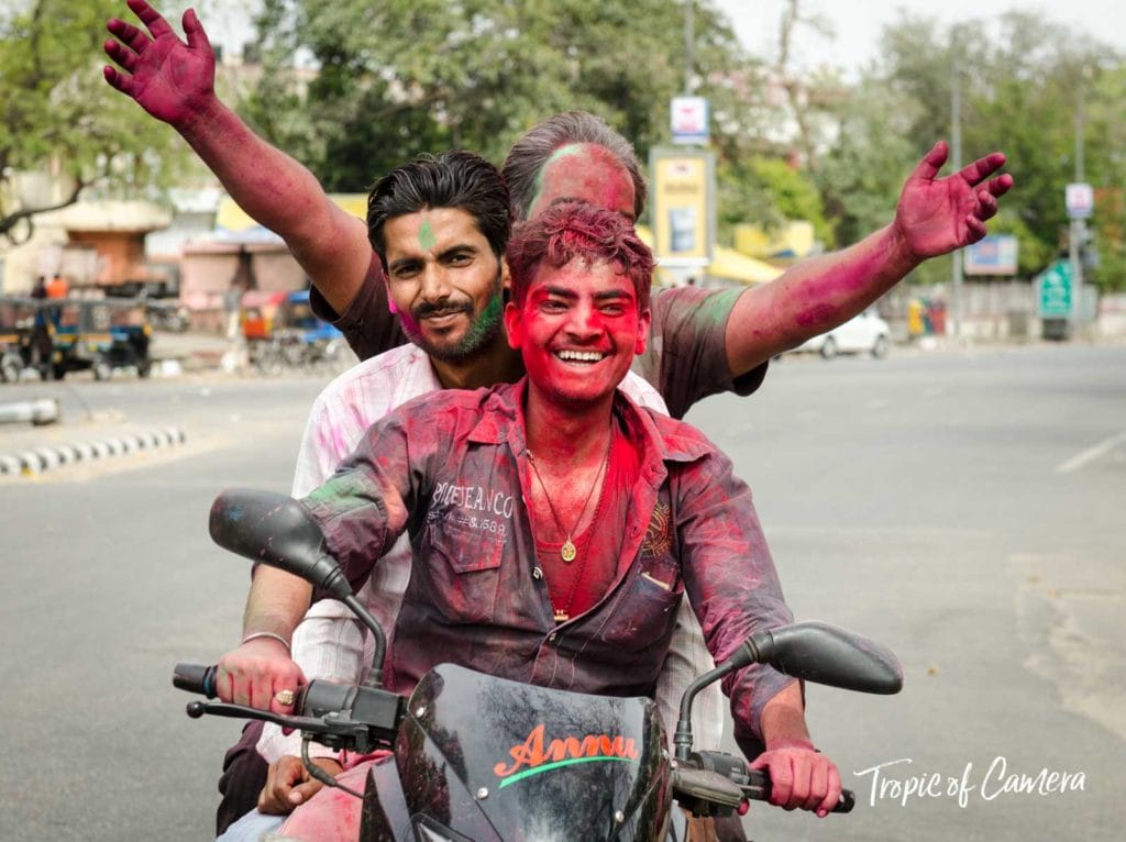 Young men riding home on a motorbike from the Holi festival in Jaipur